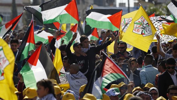 Palestinians wave their national flag and Fatah party flags as they take part in a rally marking the 12th anniversary of the death of late Palestinian leader Yasser Arafat (portrait background) in the West Bank city of Ramallah on November 10, 2016 - Sputnik International