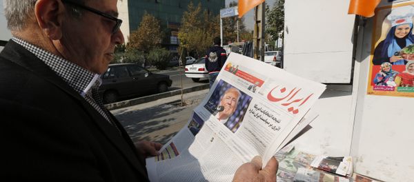 An Iranian man holds a local newspaper displaying a portrait of Donald Trump a day after his election as the new US president, in the capital Tehran, on November 10, 2016 - Sputnik International