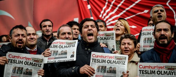 Protesters hold copies of the latest edition of the the Turkish daily newspaper Cumhuriyet as they shout slogans during a demonstration outside the newspaper's headquarters in Istanbul on November 1,2016 a day after its editor in chief was detained by police. - Sputnik International