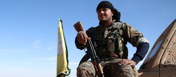 A Syrian Democratic Forces (SDF) fighter rests with his weapon on a vehicle camouflaged with mud, north of Raqqa city, Syria November 7, 2016 - Sputnik International