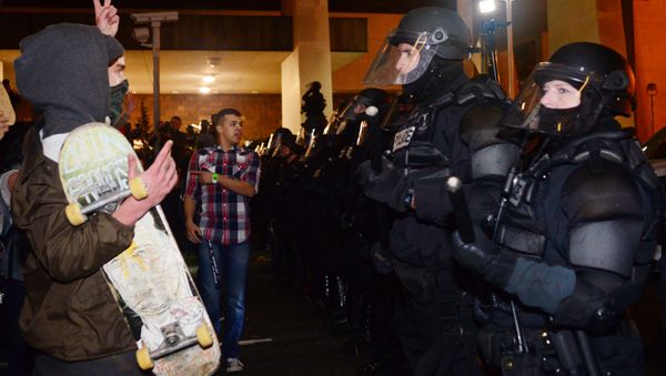 A protestor gestures at police at Pioneer Square in Portland, Oregon on November 11, 2016, to protest the election of US President-elect Donald Trump. - Sputnik International