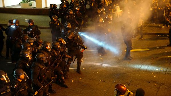 A police officer sprays the crowd with an irritant during a protest against the election of Republican Donald Trump as President of the United States in Portland, Oregon, U.S. November 12, 2016. A police officer sprays the crowd with an irritant during a protest against the election of Republican Donald Trump as President of the United States in Portland, Oregon, U.S. November 12, 2016. - Sputnik International