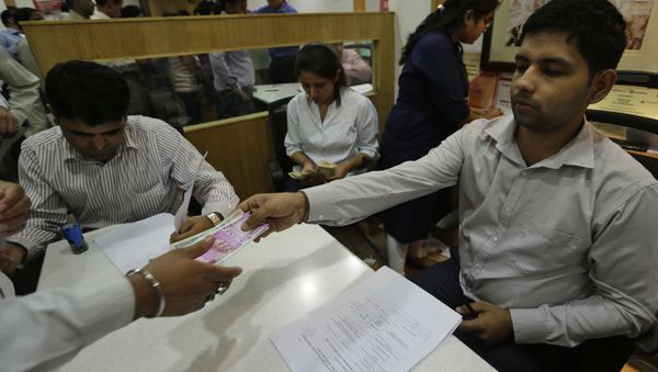 New Indian currency note of denomination 2000 is given in exchange of discontinued currency notes at a bank in New Delhi, India - Sputnik International