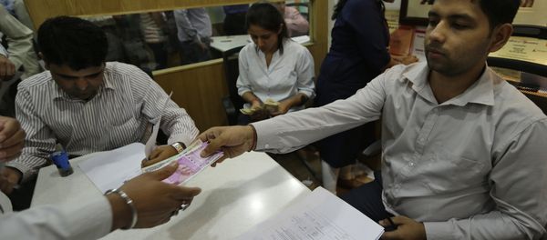 New Indian currency note of denomination 2000 is given in exchange of discontinued currency notes at a bank in New Delhi, India - Sputnik International