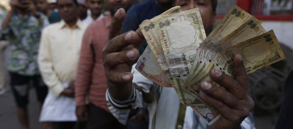An Indian man displays Indian currency notes of 1000 and 500 rupees as he stands in queue to exchange or deposit discontinued currency notes outside a post office in Ahmadabad, India, Thursday, Nov. 10, 2016. An Indian man displays Indian currency notes of 1000 and 500 rupees as he stands in queue to exchange or deposit discontinued currency notes outside a post office in Ahmadabad, India, Thursday, Nov. 10, 2016. - Sputnik International