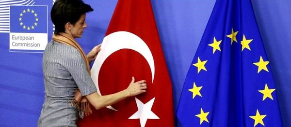 A woman adjusts the Turkish flag next to the European Union flag before the arrival of Turkish Prime Minister Ahmet Davutoglu (unseen) at the EU Commission headquarters in Brussels January 15, 2015. A woman adjusts the Turkish flag next to the European Union flag before the arrival of Turkish Prime Minister Ahmet Davutoglu (unseen) at the EU Commission headquarters in Brussels January 15, 2015. - Sputnik International