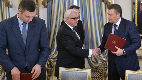 German Foreign Affairs minister Frank-Walter Steinmeier (C) and Ukrainian President Viktor Yanukovych (R) shake hands as head of Udar (Punch) party Vitali Klitschko attends after they signed the deal in Kiev on February 21, 2014 - Sputnik International