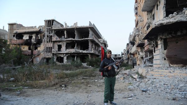 In this Feb. 23, 2016 file photo, a civilian fighter holding the Libyan flag stands in front of damaged buildings in Benghazi, Libya - Sputnik International