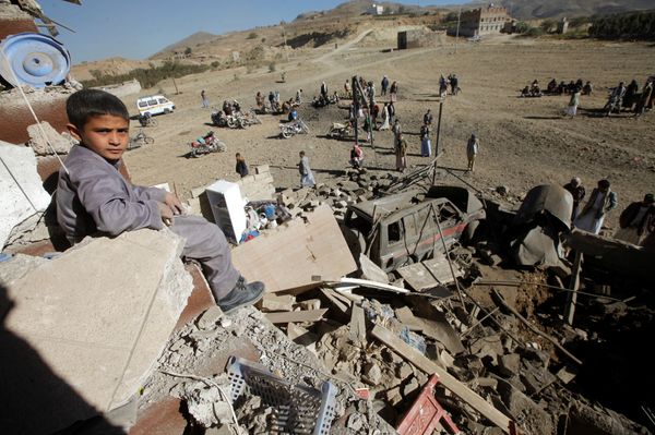 A boy looks at the camera as he sits on the wreckage of a house destroyed by a Saudi-led air strike on the outskirts of Sanaa, Yemen, November 13, 2016 - Sputnik International