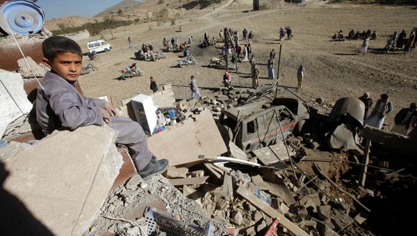 A boy looks at the camera as he sits on the wreckage of a house destroyed by a Saudi-led air strike on the outskirts of Sanaa, Yemen, November 13, 2016 - Sputnik International