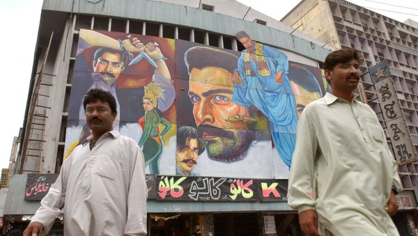 Passers-by walk in front of a movie theater in Karachi, Pakistan (File) Passers-by walk in front of a movie theater in Karachi, Pakistan (File) - Sputnik International