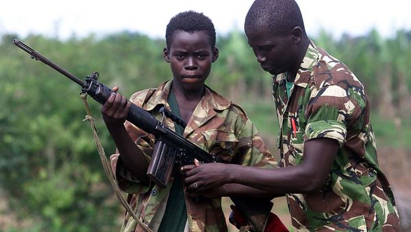 A fourteen year old child soldier for the Sierra Leone Army, Abu Kamara, left, is helped with his British self Loading rifle (SLR) by another soldier while protecting the small town of Ropath near Masiaka, 55 km east of the capital Freetown, Tuesday May 23, 2000 A fourteen year old child soldier for the Sierra Leone Army, Abu Kamara, left, is helped with his British self Loading rifle (SLR) by another soldier while protecting the small town of Ropath near Masiaka, 55 km east of the capital Freetown, Tuesday May 23, 2000 - Sputnik International
