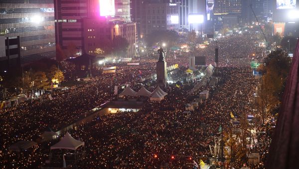 Protesters hold candles during an anti-government rally in central Seoul on November 19, 2016 Protesters hold candles during an anti-government rally in central Seoul on November 19, 2016 - Sputnik International