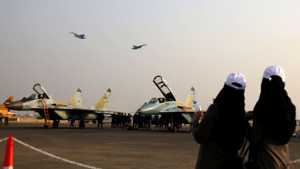 Two female spectators gaze at two Sukhoi Su-27 jets from the Russian Knights aerobatic team as they fly during an airshow in Iran's southern resort island of Kish on November 16, 2016 - Sputnik International