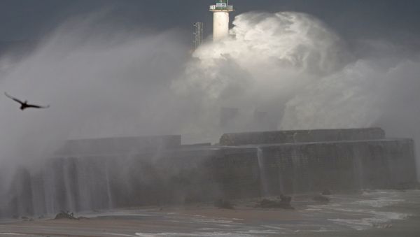 Waves crash against a lighthouse as the wind blows at around 120 kph (75mph), in Boulogne-sur-Mer, northern France - Sputnik International