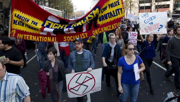 Demonstrators holds a banner as they protest in Pennsylvania Avenue outside of the Trump Hotel in Washington in opposition of President-elect Donald Trump, on Saturday, Nov. 19, 2016. - Sputnik International