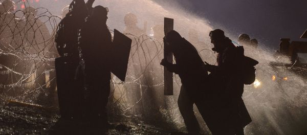 Police use a water cannon on protesters during a protest against plans to pass the Dakota Access pipeline near the Standing Rock Indian Reservation, near Cannon Ball, North Dakota, U.S. November 20, 2016. Police use a water cannon on protesters during a protest against plans to pass the Dakota Access pipeline near the Standing Rock Indian Reservation, near Cannon Ball, North Dakota, U.S. November 20, 2016. - Sputnik International