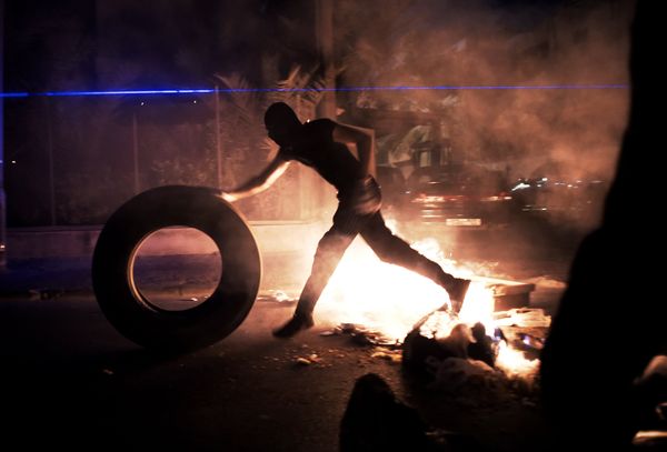 A Bahraini protester puts tyre in fire during clashes between protesters and riot police following a protest to demand more rights and against the ruling regime, late on July 10, 2014 in the village of Sanabis, west of Manama. - Sputnik International