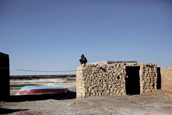 Iranian boys sit on the roof of a mud-house in Adimi village in Hamoon wetland near the Zabol town in southeastern province of Sistan-Baluchistan bordering Afghanistan on February 2, 2015. - Sputnik International