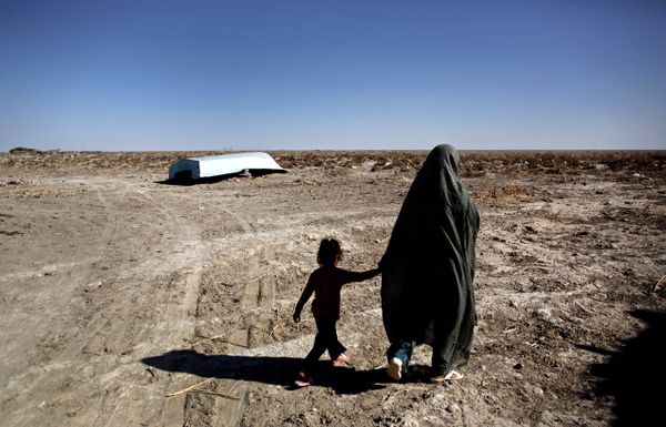 An Iranian woman walks with her daughter past an abandoned boat in Sikh Sar village at Hamoon wetland near the Zabol town, in southeastern province of Sistan-Baluchistan bordering Afghanistan on February 2, 2015.  - Sputnik International