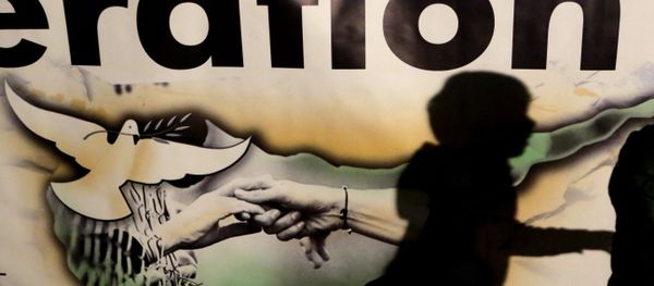 A shadow of a boy is seen on a banner showing the Cyprus island with two hands and a pigeon during a peace rally to support the peace talks inside the UN buffer zone Green Line, in the divided capital Nicosia in the eastern Mediterranean island of Cyprus, Monday, Nov. 21, 2016. Hundreds of Greek and Turkish Cypriots are demonstrating for peace as the ethnically divided island's rival leaders continue complex reunification talks at a Swiss resort. - Sputnik International
