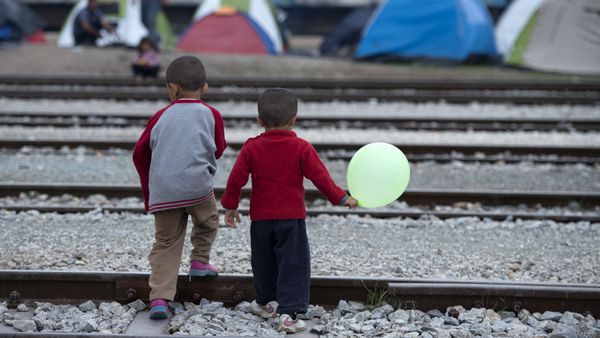 Children cross rail tracks at a makeshift camp for migrants and refugees near the village of Idomeni not far from the Greek-Macedonian border Children cross rail tracks at a makeshift camp for migrants and refugees near the village of Idomeni not far from the Greek-Macedonian border - Sputnik International
