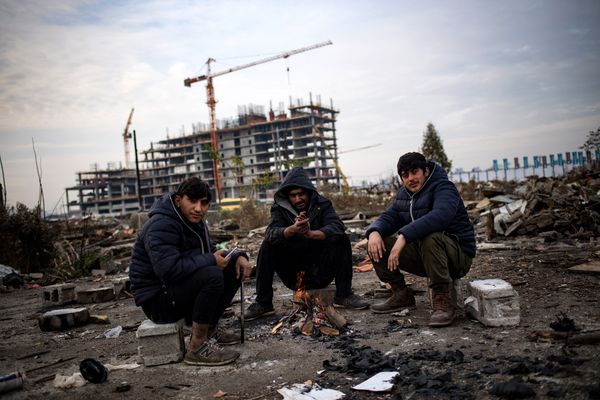 Migrants warm up near a makeshift shelter in an abandoned warehouse in Belgrade on November 16, 2016 - Sputnik International