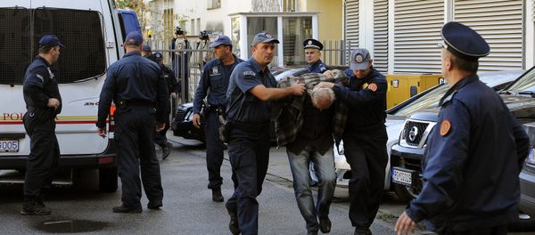 A man is escorted by Montenegrin police officers to the special court in Podgorica on October 16, 2016 - Sputnik International