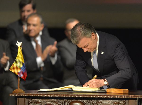 Colombian President Juan Manuel Santos (L) signs the historic peace agreement between the Colombian government and the Revolutionary Armed Forces of Colombia (FARC), at the Colon Theater in Bogota, Colombia, on November 24, 2016 - Sputnik International