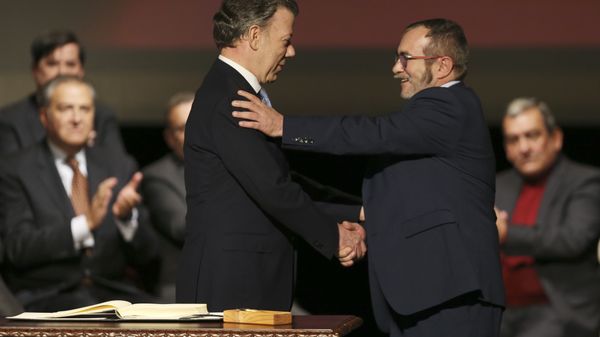 Colombia's President Juan Manuel Santos, left, shakes hands with with Rodrigo Londono, known as Timochenko, the top leader of the Revolutionary Armed Forces of Colombia, FARC, after signing a revised peace pact at Colon Theater in Bogota, Colombia, Thursday, Nov. 24, 2016 Colombia's President Juan Manuel Santos, left, shakes hands with with Rodrigo Londono, known as Timochenko, the top leader of the Revolutionary Armed Forces of Colombia, FARC, after signing a revised peace pact at Colon Theater in Bogota, Colombia, Thursday, Nov. 24, 2016 - Sputnik International