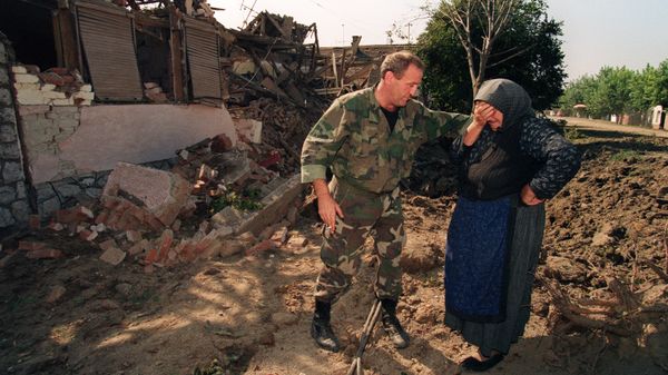 A Croatian National Guardsman comforts an old woman on September 26, 1991, outside her home which was destroyed in an air raid during the night by Yugoslav Serbian Federal air forces - Sputnik International