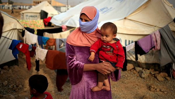 A woman who fled from Mosul carries her five-month-old daughter Ritadj, who was born under Islamic State rule and has no identity documents recognised by Iraqi authorities, in Debaga refugee camp, Iraq November 10, 2016 - Sputnik International