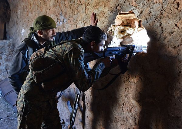 A fighter from the Syrian pro-government forces mans a riffle inside a damaged house in the recently recaptured village of Joubah during an offensive towards the area of Al-Bab in Aleppo province, on November 25, 2016 - Sputnik International