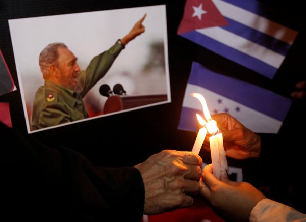 People place candles beside a picture of Fidel, as part of a tribute, following the announcement of the death of Cuban revolutionary leader Fidel Castro, in Tegucigalpa, Honduras November 26, 2016 - Sputnik International