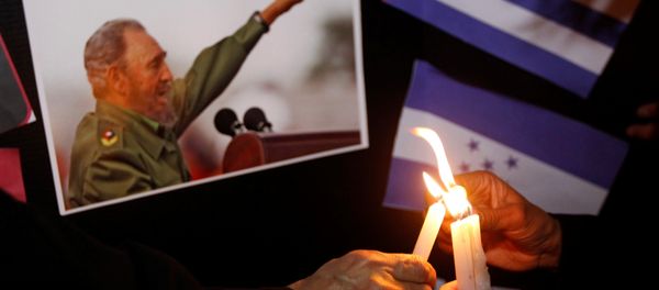 People place candles beside a picture of Fidel, as part of a tribute, following the announcement of the death of Cuban revolutionary leader Fidel Castro, in Tegucigalpa, Honduras November 26, 2016 - Sputnik International