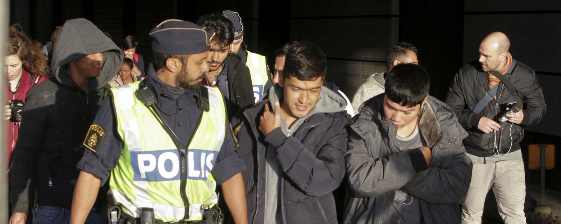 A group of migrants off an incoming train walk down a platform as they are accompanied by the police at the Swedish end of the bridge between Sweden and Denmark near Malmoe on 12 November 2015. - Sputnik International, 1920, 26.08.2021