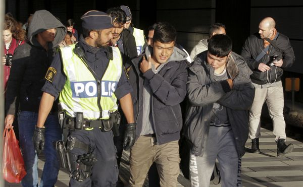 A group of migrants off an incoming train walk down a platform as they are accompanied by the police at the Swedish end of the bridge between Sweden and Denmark near Malmoe on November 12, 2015. - Sputnik International