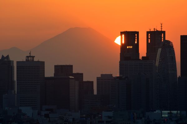 This picture taken on November 7, 2016 shows the sun setting behind the Japan's highest mountain Mount Fuji and skyscrapers in Tokyo's Shinjuku area. - Sputnik International