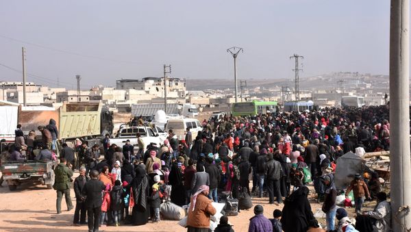 Syrians that evacuated the eastern districts of Aleppo gather to board buses, in a government held area in Aleppo, Syria in this handout picture provided by SANA on November 29, 2016. - Sputnik International