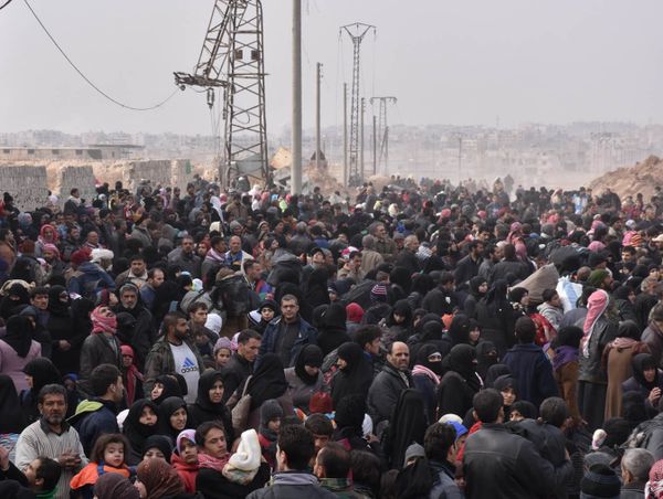 Syrians that evacuated the eastern districts of Aleppo gather to board buses, in a government held area in Aleppo, Syria in this handout picture provided by SANA on November 29, 2016. - Sputnik International