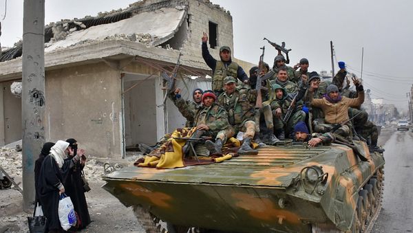 Syrian pro-government forces sit on a military vehicle driving past residents fleeing the eastern part of Aleppo and gathering in Masaken Hanano, a former rebel-held district which was retaken by the regime forces last week, on November 30, 2016. Syrian pro-government forces sit on a military vehicle driving past residents fleeing the eastern part of Aleppo and gathering in Masaken Hanano, a former rebel-held district which was retaken by the regime forces last week, on November 30, 2016. - Sputnik International