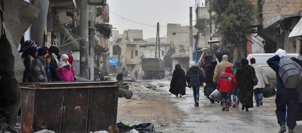 Syrian residents fleeing the eastern part of Aleppo walk through a street in Masaken Hanano, a former rebel-held district which was retaken by the regime forces last week. (File) - Sputnik International