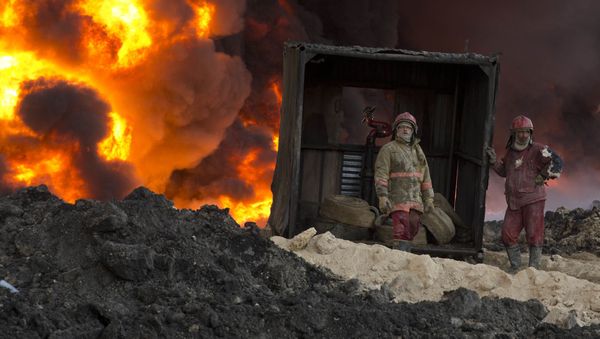 Fire fighters work to quell an oil fire set by Islamic State militants in Qayara, south of Mosul, Iraq, Monday, Nov. 28, 2016.  - Sputnik International