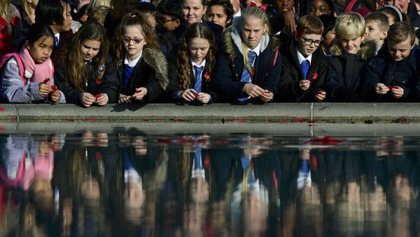 School children throw poppies into a fountain during an Armistice Day event at Trafalgar Square in London, Britain November 11, 2016. - Sputnik International