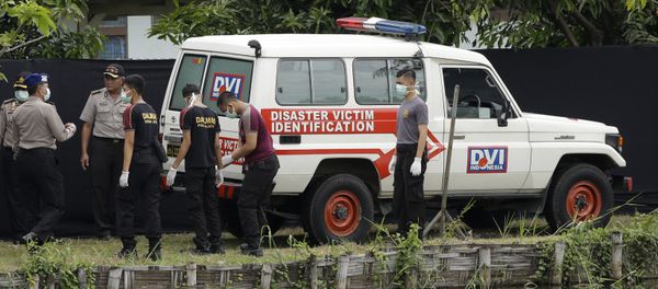 Indonesian police officers stand near an ambulance used to carry the bodies of the victims of a plane crash outside the morgue at the police hospital in Surabaya, East Java, Indonesia (File) - Sputnik International