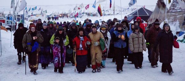 In this Thursday, Dec. 1, 2016 photo, Beatrice Menase Kwe Jackson, center, walks with Daniel Emory, both of the Ojibwe Native American tribe as they lead a procession to the Cannonball river for a traditional water ceremony at the Oceti Sakowin camp where people have gathered to protest the Dakota Access oil pipeline in Cannon Ball, N.D. - Sputnik International