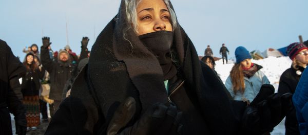 A woman watches the sunrise in Oceti Sakowin camp as water protectors continue to demonstrate against plans to pass the Dakota Access pipeline near the Standing Rock Indian Reservation, near Cannon Ball, North Dakota, U.S. December 3, 2016 A woman watches the sunrise in Oceti Sakowin camp as water protectors continue to demonstrate against plans to pass the Dakota Access pipeline near the Standing Rock Indian Reservation, near Cannon Ball, North Dakota, U.S. December 3, 2016 - Sputnik International