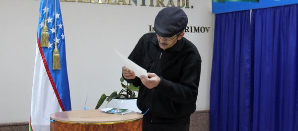 A man studies his ballot during the presidential election in Tashkent, Uzbekistan, December 4, 2016 - Sputnik International