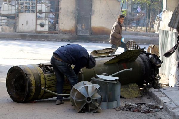 A man inspects an unexploded missile in the rebel-held besieged al-Qaterji neighbourhood of Aleppo, Syria November 28, 2016 - Sputnik International
