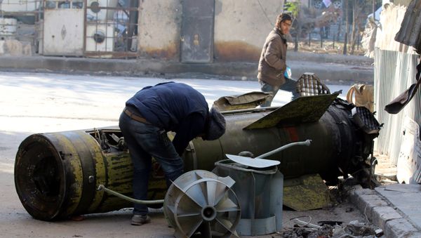 A man inspects an unexploded missile in the rebel-held besieged al-Qaterji neighbourhood of Aleppo, Syria November 28, 2016 - Sputnik International